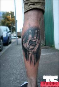 a hand tattoo on the leg