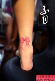 Gambe di ragazze, piccoli e popolari tatuaggi con fiocco