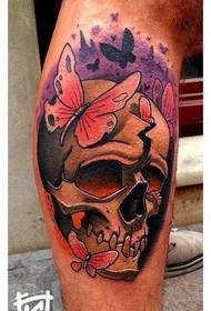 un tatuatge de papallona de crani colorit a la vedella