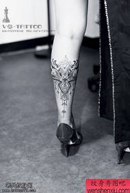 Creatieve kanttatoeages op de benen worden gedeeld door tatoeages