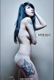 La figura del tatuaje comparte las piernas de la mujer como una imagen del cuerpo del tatuaje