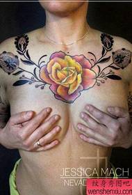 Un bell tatuatge de rosa pop sobre el pit d'una bella dona