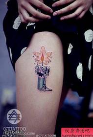 I tatuaggi colorati delle candele delle gambe della donna sono condivisi dai tatuaggi