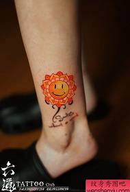 Kāju mīļa smaidoša seja ar ziedu tetovējuma rakstu