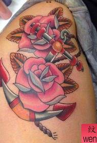 L'immagine dello spettacolo di tatuaggi consiglia un modello di tatuaggio con rose di ancoraggio di colore per le gambe di una donna
