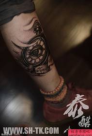 un motif de tatouage des yeux d'horloge sur la jambe