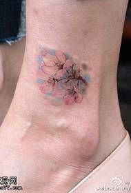 足首に薄桃の花のタトゥー