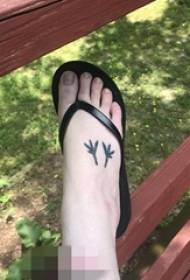 fotografi me tatuazhe me gjethe të zeza dhe të bardha në skajin e vajzave