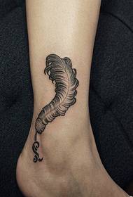 Bella immagine graziosa del modello del tatuaggio della piuma della caviglia femminile
