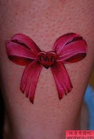 Ноги красивої дівчини популярні з малюнком татуювання з лука