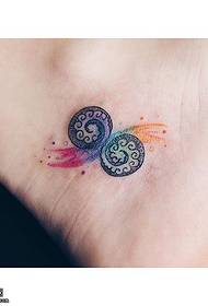 twee kleine totem tattoo-patronen bij de enkel