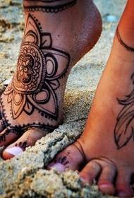 vrouwelijke bijpassende voeten op hetzelfde bijpassende tattoo-patroon
