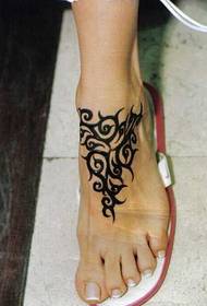 черная татуировка тотема на ноге