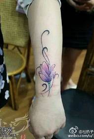 riešo tatuiruotės piešinys, kuriame yra dedama lotoso gėlė