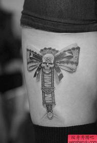 Bellissimo disegno del tatuaggio con fiocco in pizzo sulle gambe delle ragazze