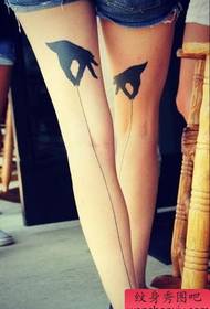 एक टोटेम हाथ और सीधे टैटू पैटर्न के साथ लड़की के पैर
