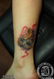 woman's ankle color mask tattoo work
