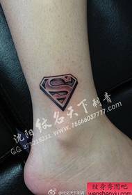 caviglia della ragazza presso il piccolo popolare modello di tatuaggio del logo Superman