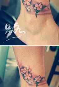глежањ девојке на малом популарном узорку тетоваже са цветањем трешње
