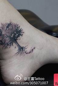 小さなツバメのタトゥーパターンを持つ足首の小さな木の女の子