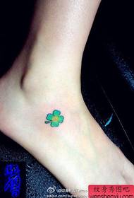 flickors fötter är små och populära tatueringsmönster för fyrklöver