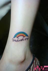 foto di un piccolo tatuaggio inglese alla caviglia arcobaleno