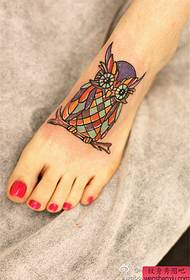 La barra dello spettacolo del tatuaggio ha raccomandato un modello del tatuaggio del gufo di colore sul collo del piede