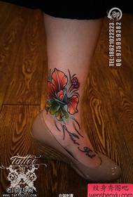Trabalho de tatuagem de flor de cor de pé feminino