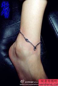 Caviglie da bambina con un piccolo disegno del tatuaggio alla caviglia