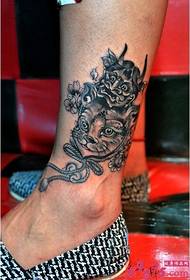 Immagine creativa del tatuaggio del tatuaggio alla caviglia simile a un gatto prepotente