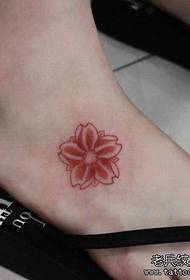 un piccolo tatuaggio di fiori di ciliegio sul collo del piede della ragazza