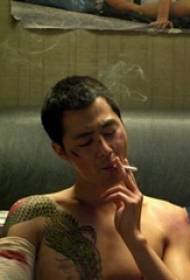 Tattoo kunstenaar film karakter borst geschilderd draak tattoo foto
