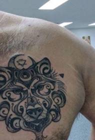 un bellissimo tatuaggio lupo in stile decorativo nero sul petto maschile