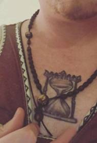 Tetovējums smilšu pulksteņa vīrietis uz krūtīm melni pelēks smilšu pulksteņa tetovējums attēls