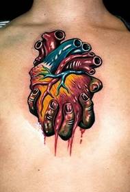 mano del petto di personalità maschile che tiene il tatuaggio del cuore