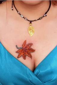 a woman's chest with a maple leaf tattoo