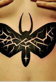 skönhet bröstet under en totem fjäril tatuering mönster