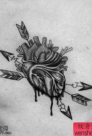 Oibríonn an tattoo croí cruthaitheach ag comhroinnt figiúr tattoo