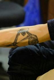 Dječakova ruka s tetovažom kostiju na slici tetovaže od crne sive kosti