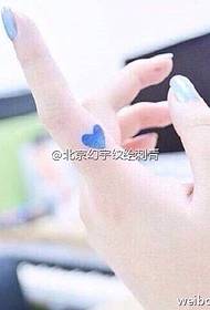 Blue heart tattoo pattern on the finger