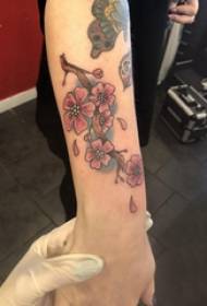 Arm tatueringsmaterial tjejfärgad tatuerad bild med körsbärsblomning