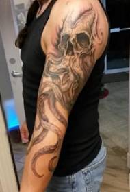 Braço do braço material menino tatuagem na imagem de tatuagem caveira preta polvo