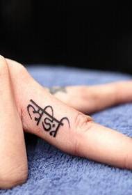 Kleines Sanskrit Tattoo am Finger
