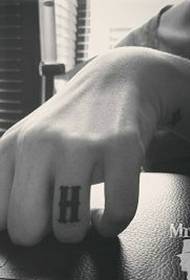 H-karakter tattoo patroan op 'e finger