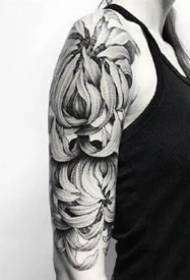 Crisantema gris negre: un bon tatuatge de crisantem negre i gris als braços i a les cames