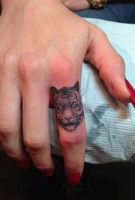 Stylike lytse dierkop tatoet op finger