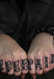 Kahden sormen kädellä on tyylikäs englantilainen tatuointi