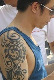 Huang Guanzhong, estrela de tatuaje chinés, sobre unha tatuaxe de tótem tribal negro