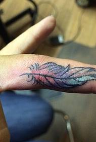 Mały tatuaż z piór na palcu