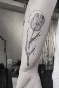 Una serie di piccoli disegni di tatuaggi freschi con linee geometriche sul braccio